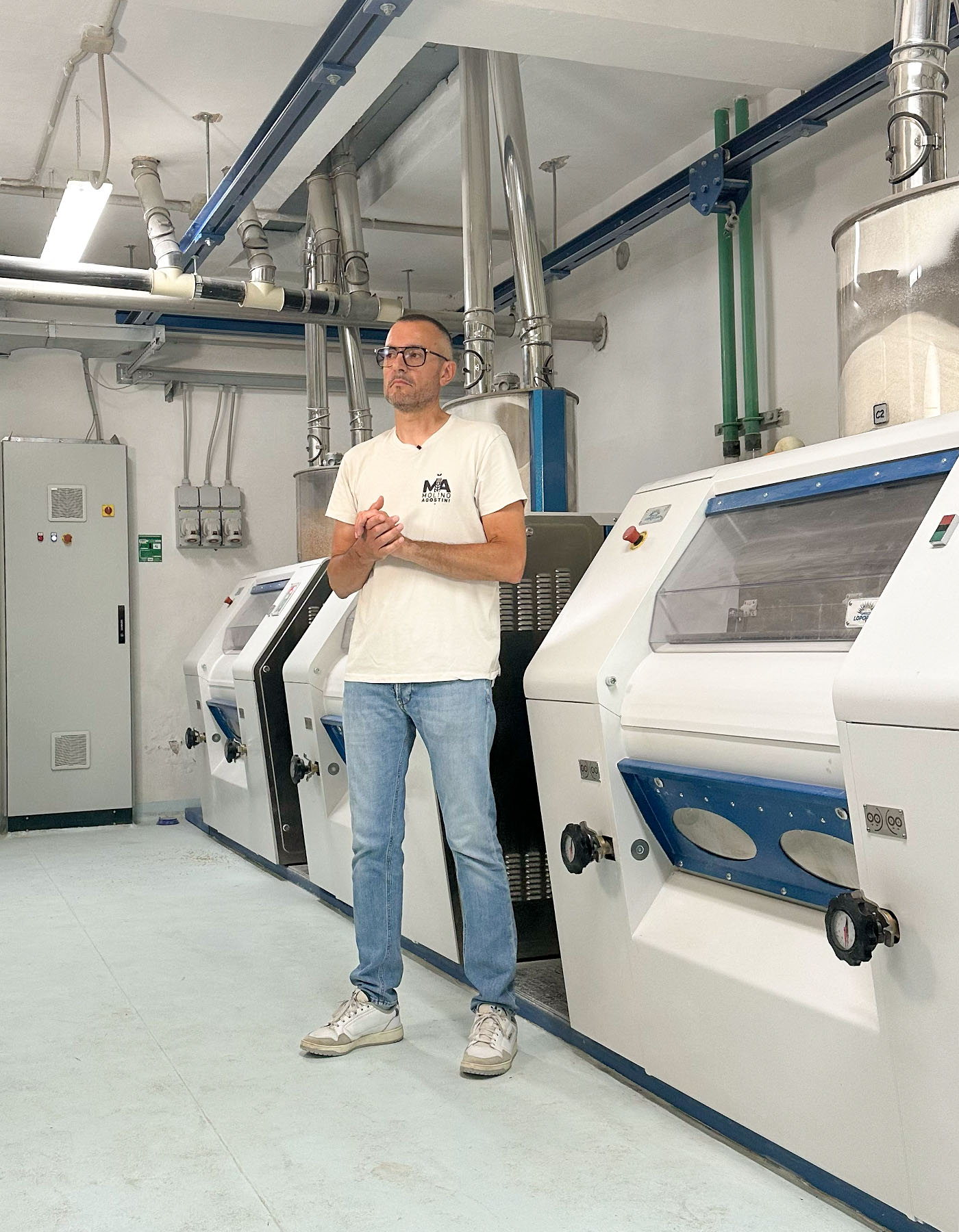 Molitore al lavoro tra i macchinari del molino