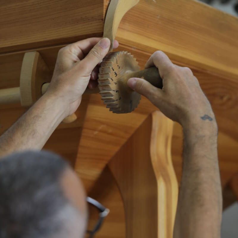Mani che lavorano il grano macinato a pietra